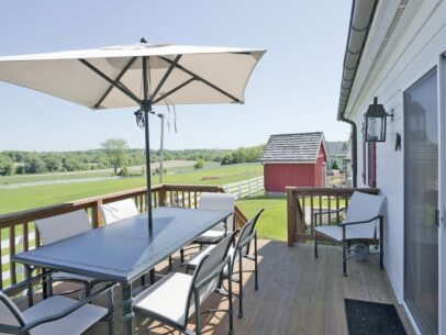 deck with umbrella overlooking land off of Carriage House